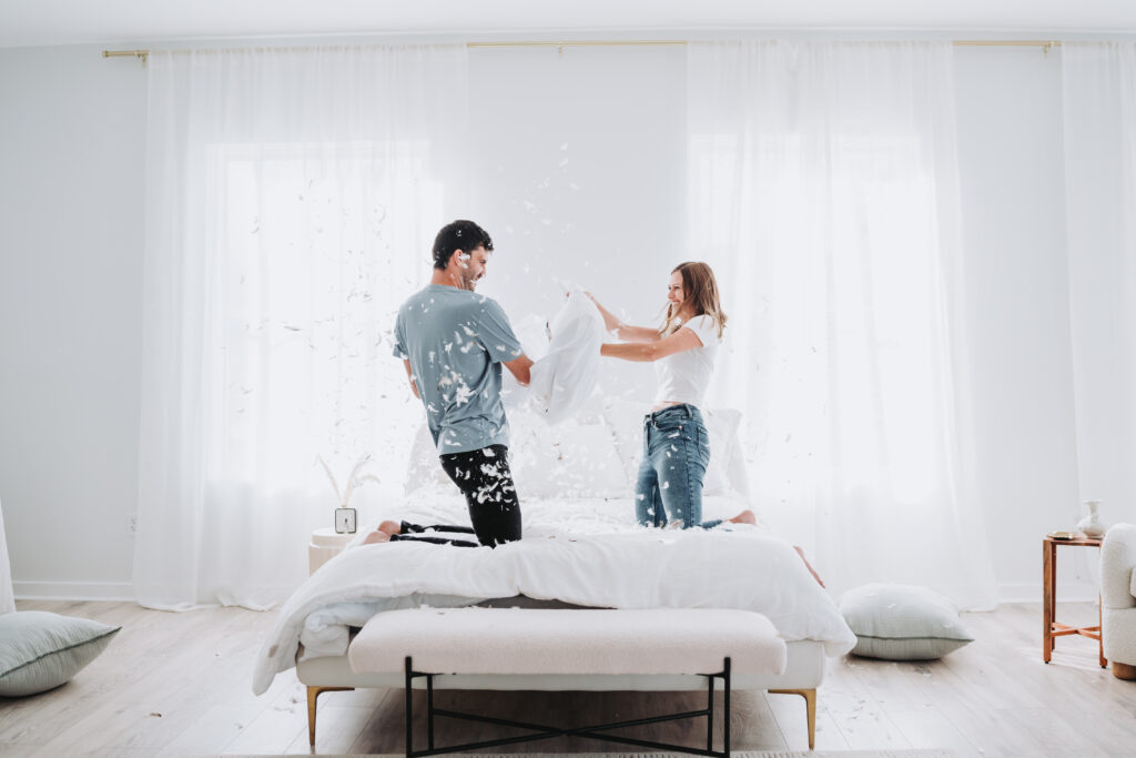 Couple pillow fight on the bed photography session