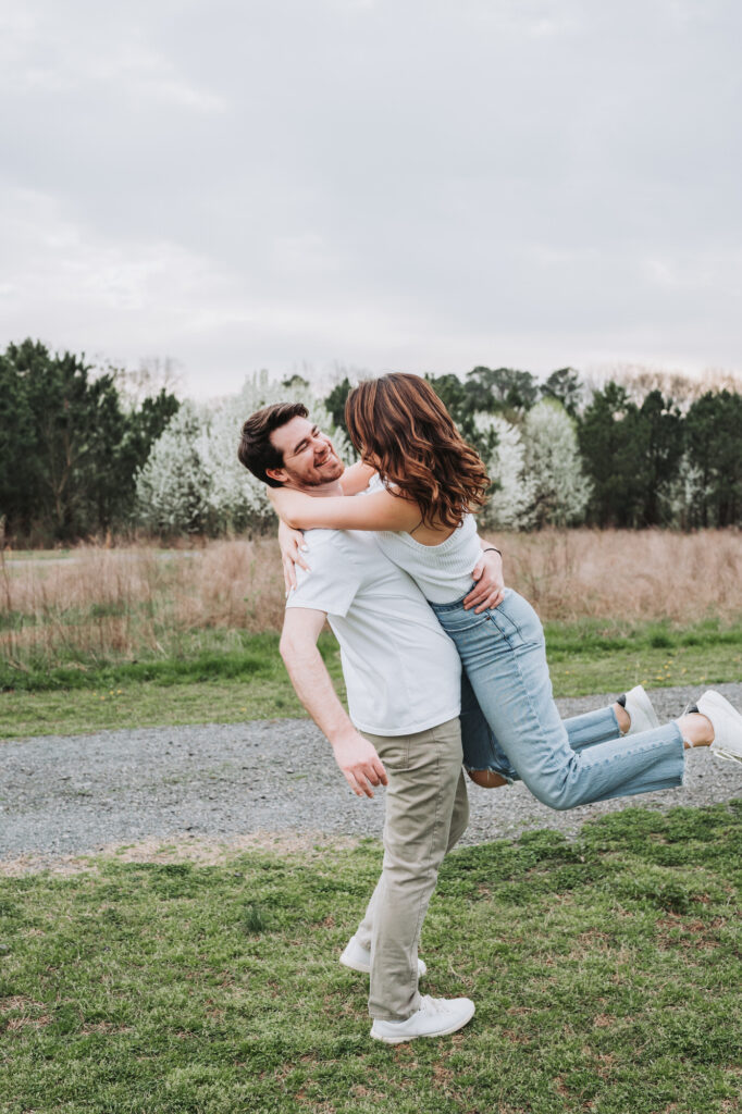 Man spins woman during engagement photos at Garrard landing park.