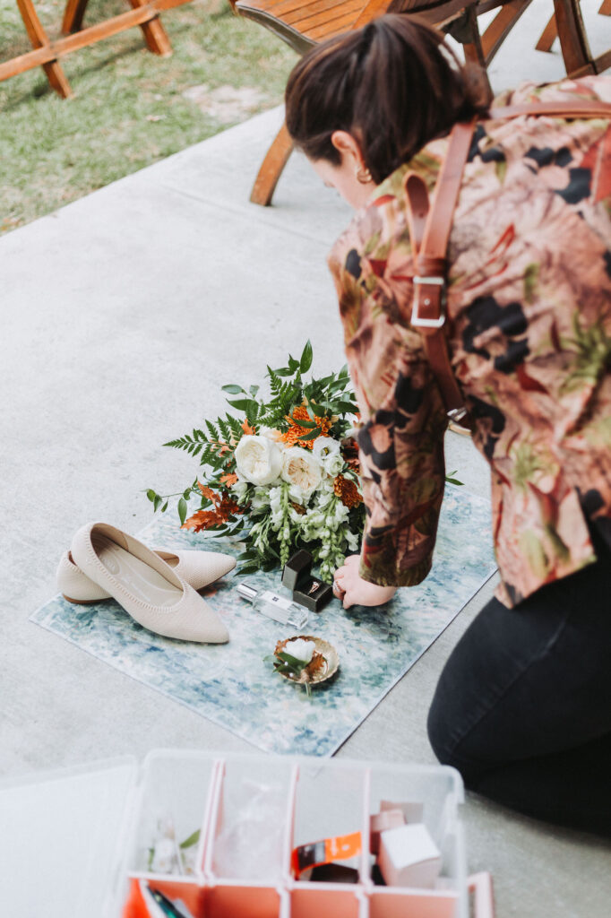 Photographer putting flat lay together with details. Wedding at Flat Rock Farms
