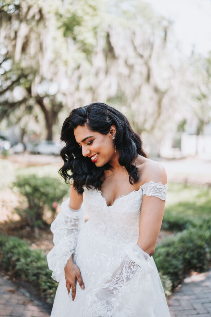 Indian bride plays with dress outside of Harper Fowlkes house in Savannah, GA.