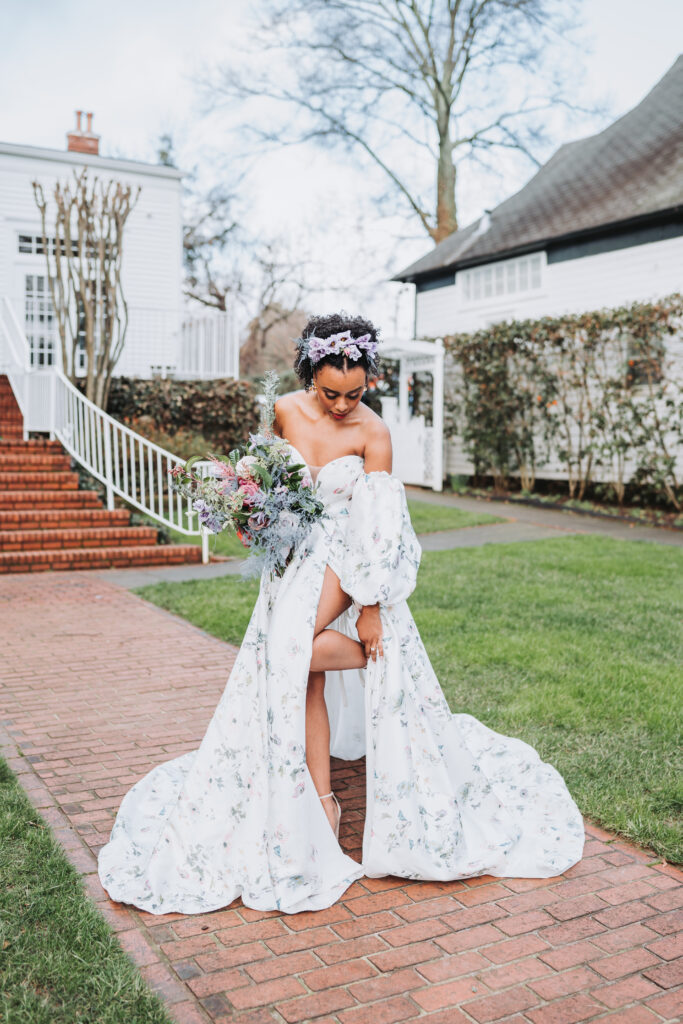 Bride fixes shoe in floral dress