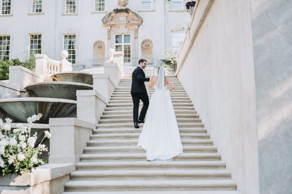 Bride and Groom walk up the grand stairs of the Swan House.
