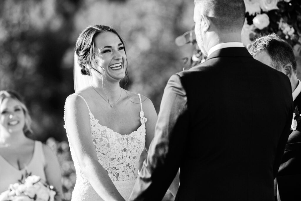 Bride smiles at groom during ceremony.