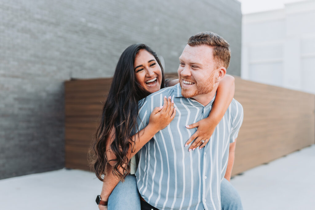 Guy gives girl a piggyback ride during their Jeni's ice cream engagement session.