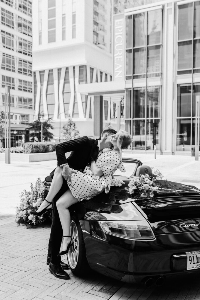 Groom kisses bride on car during city elopement at Epicurean Hotel atlanta