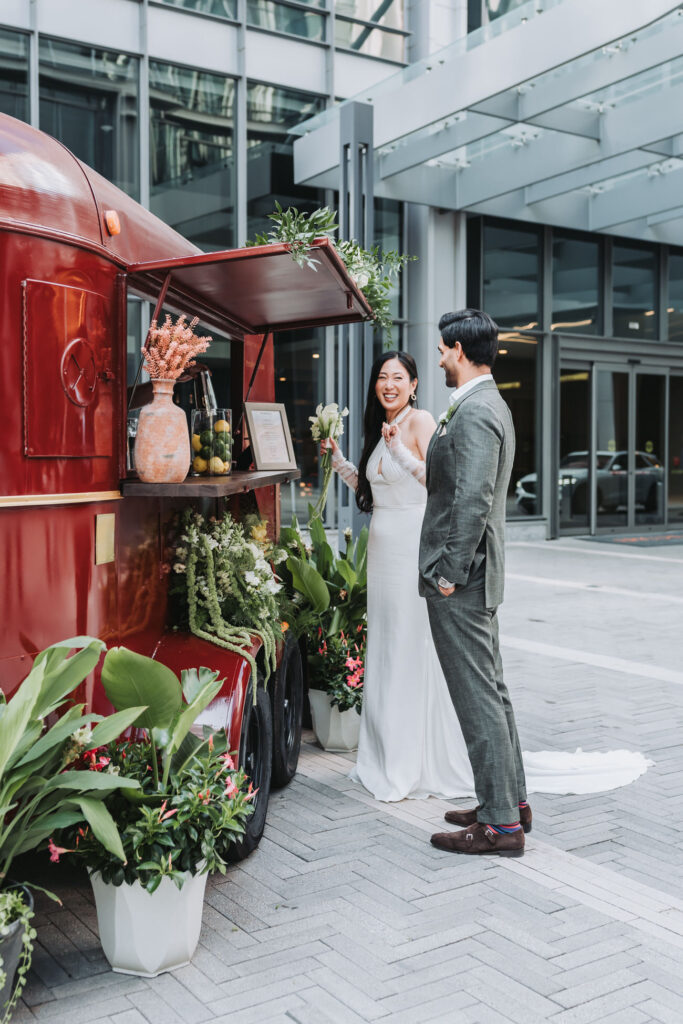 Bride shows excitement while her and the groom wait for their drink from a bar cart