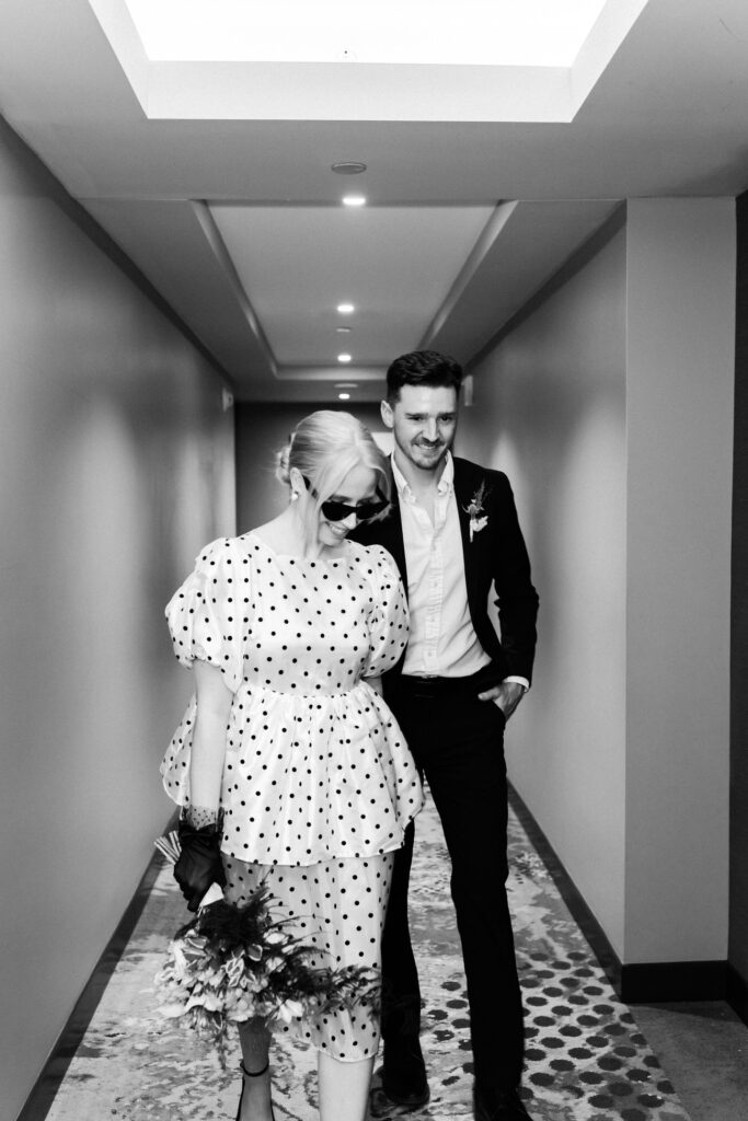 Bride and groom walk through hotel hallway during their city elopement at Epicurean Hotel Atlanta