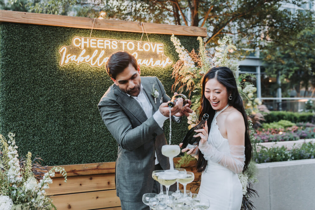 Bride and groom pour champagne in their champagne tower during their wedding at Epicurean Hotel atlanta