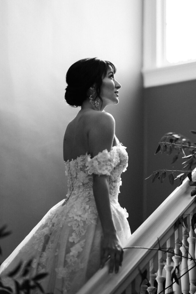 Bride shows off the back of her lacey off the shoulder Pronovias wedding dress.