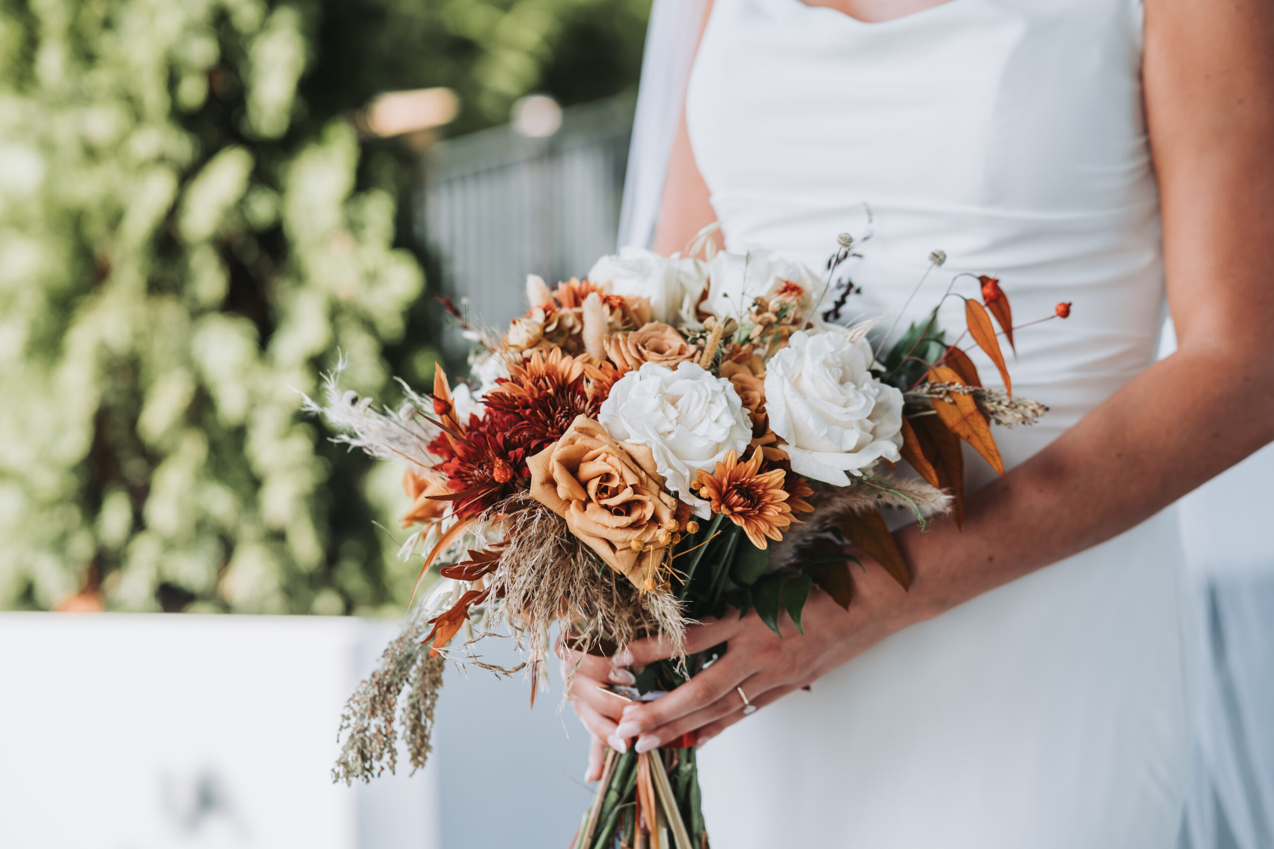 Bride holding fall wedding flowers in bouquet