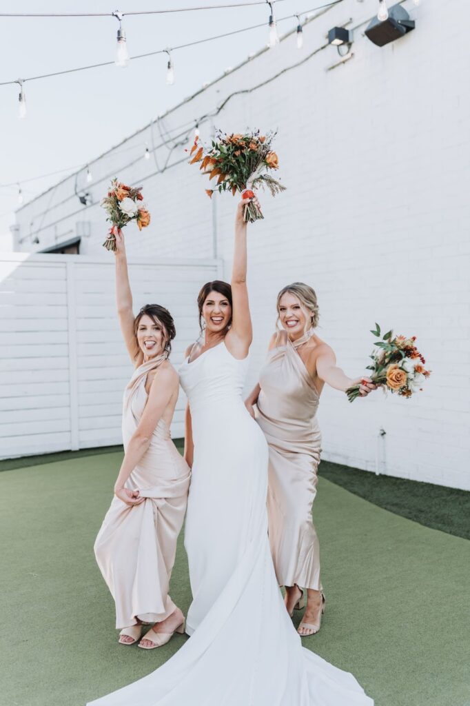 bride with her bridesmaids holding flower bouquets