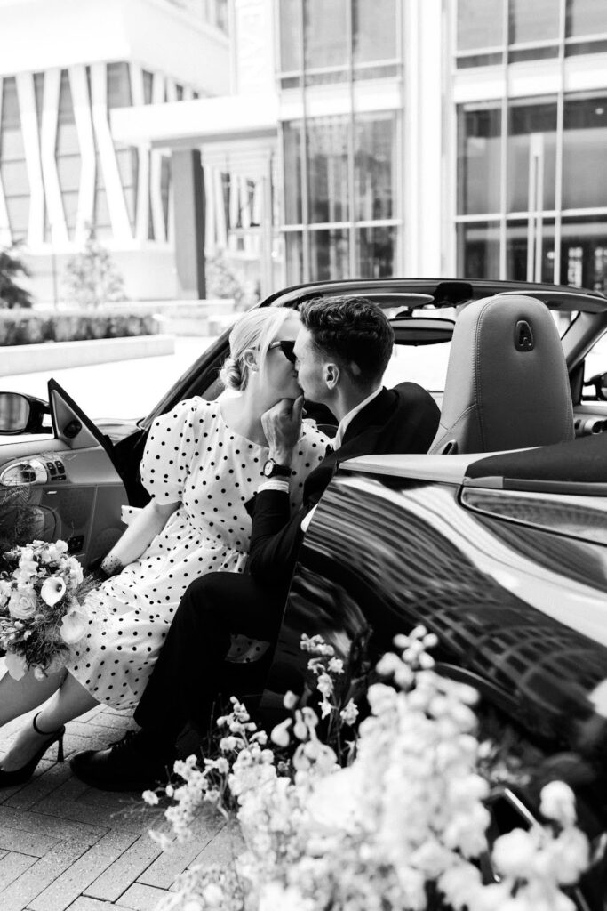 An engaged couple kissing in a car