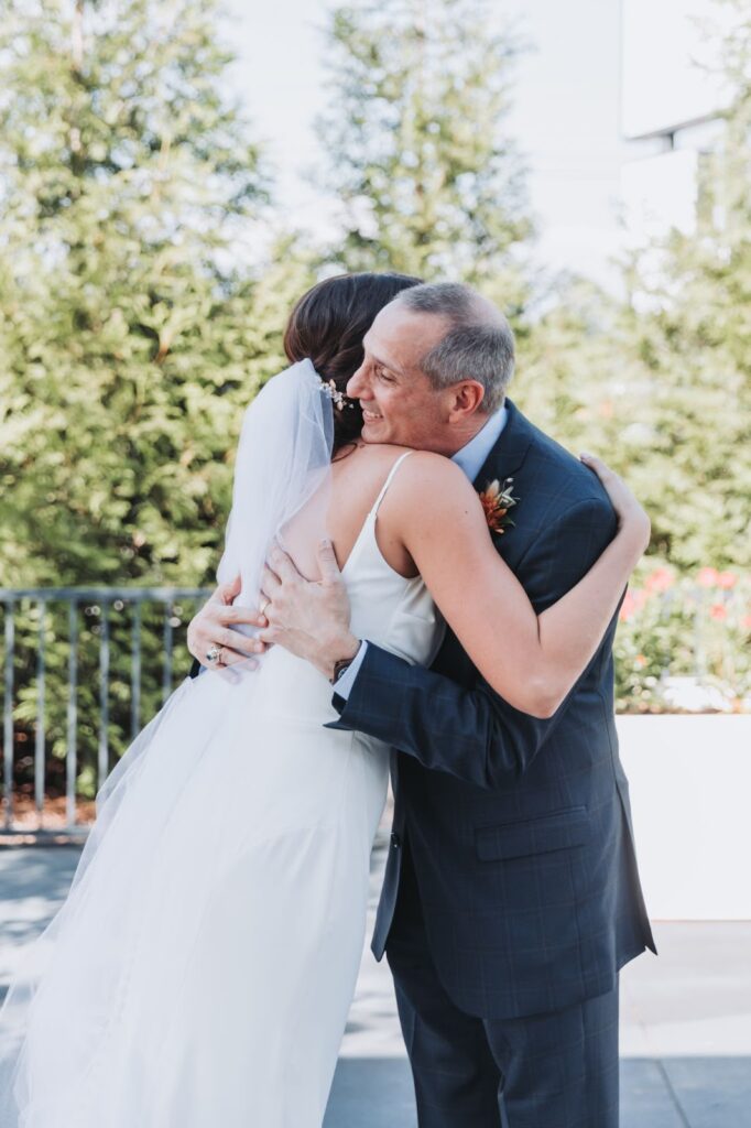father and bride hugging