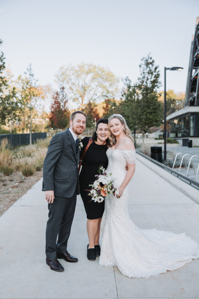 Atlanta wedding photographer smiles with bride and groom 