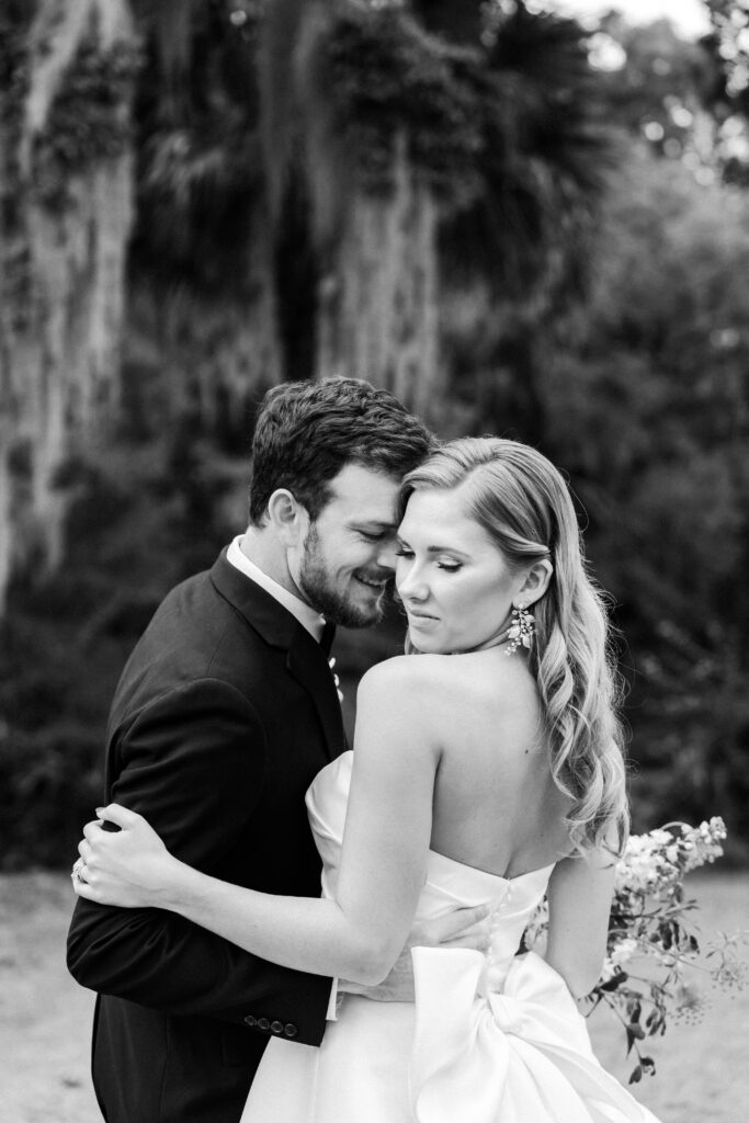 black and white photo of groom nestled into bride.