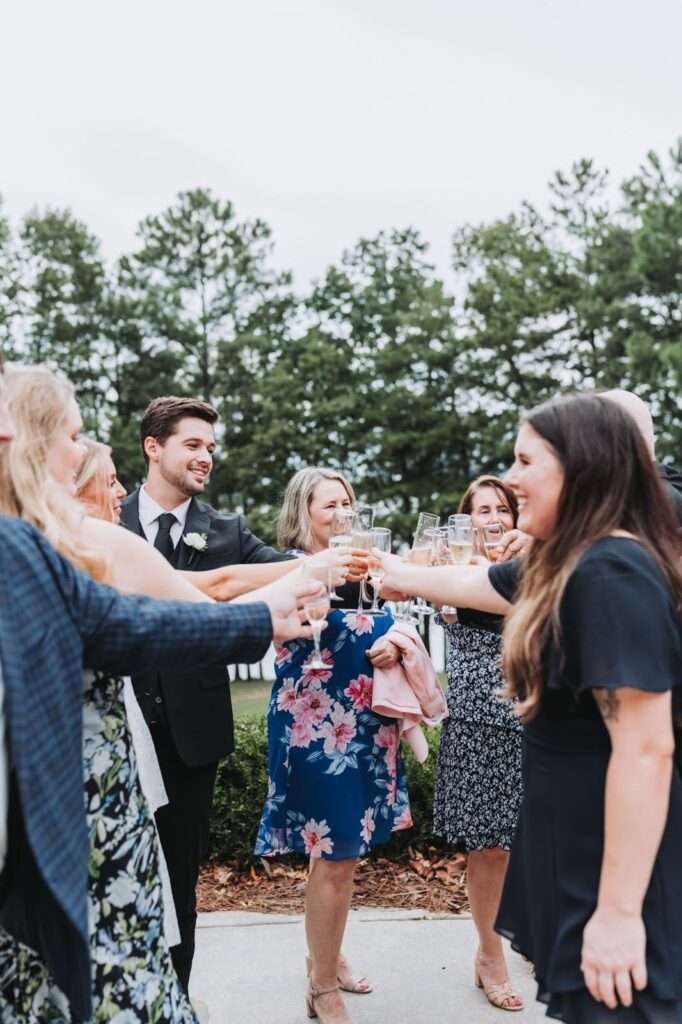 wedding party and guests toasting champagne at outdoor wedding