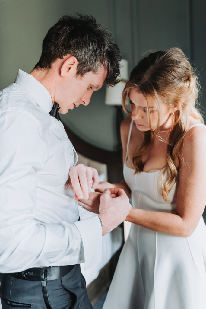 woman adjust man's sleeve buttons