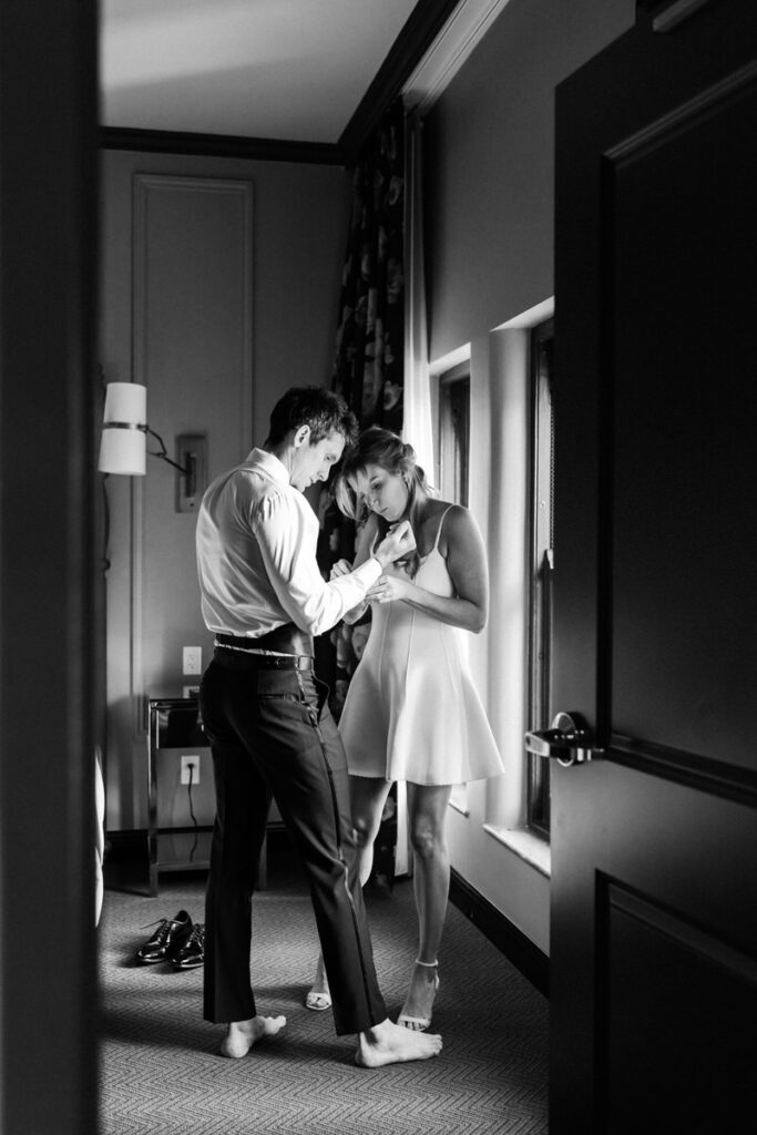 woman and man get dressed together for their engagement photos