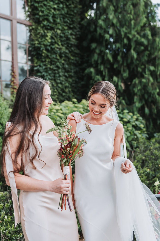 bride and bridesmaid laughing.