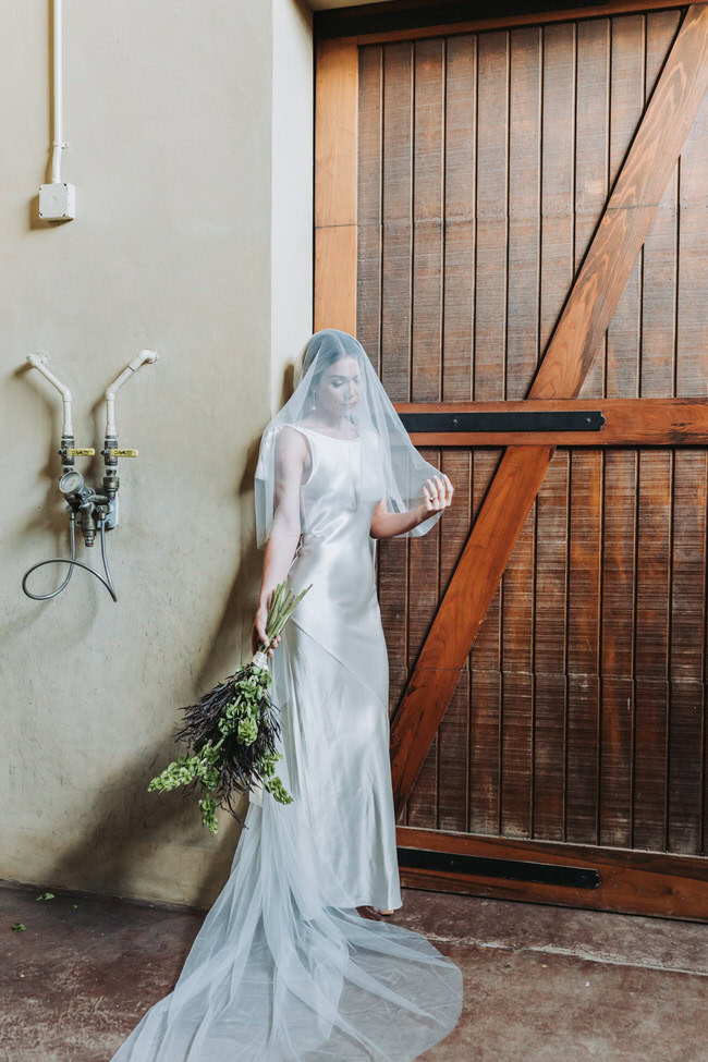 bride holds her bouquet and touches her veil