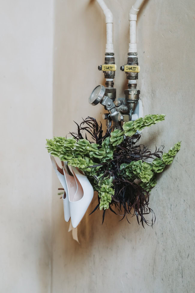 wedding shoes and bouquet hand on the pipes