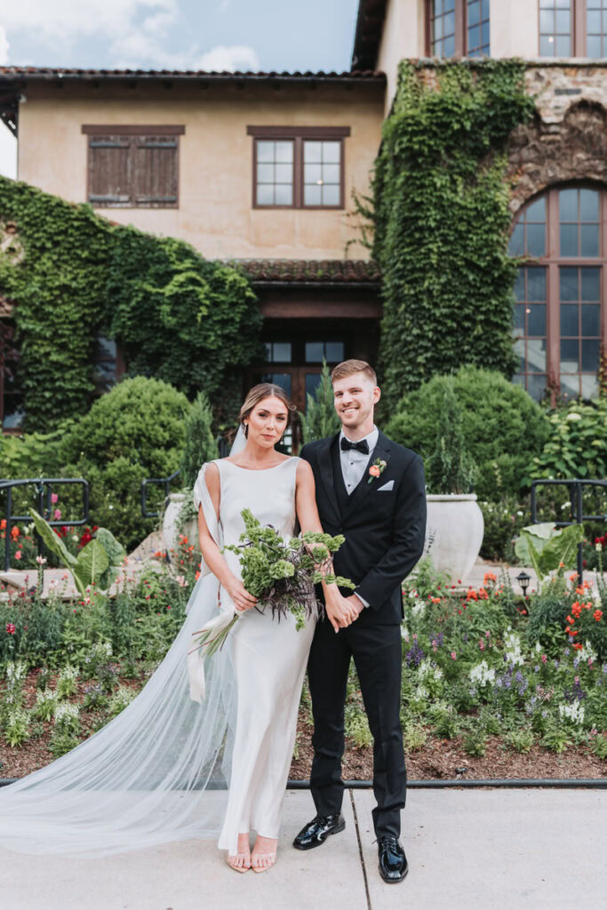 bride and groom hold hands and smiles in front of Montaluce wedding venue.