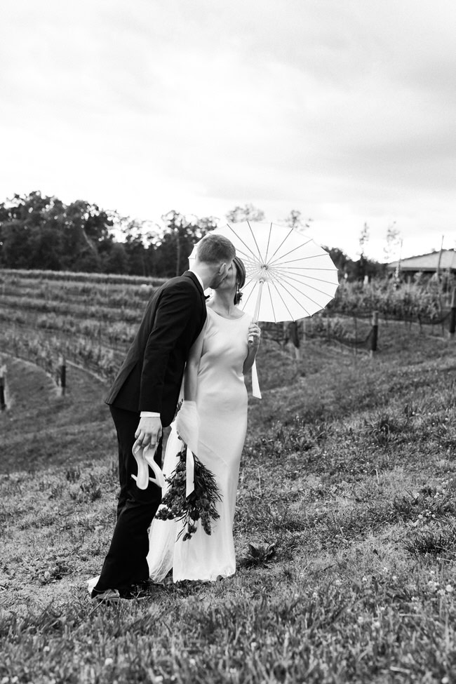 bride and groom kiss in the vineyard