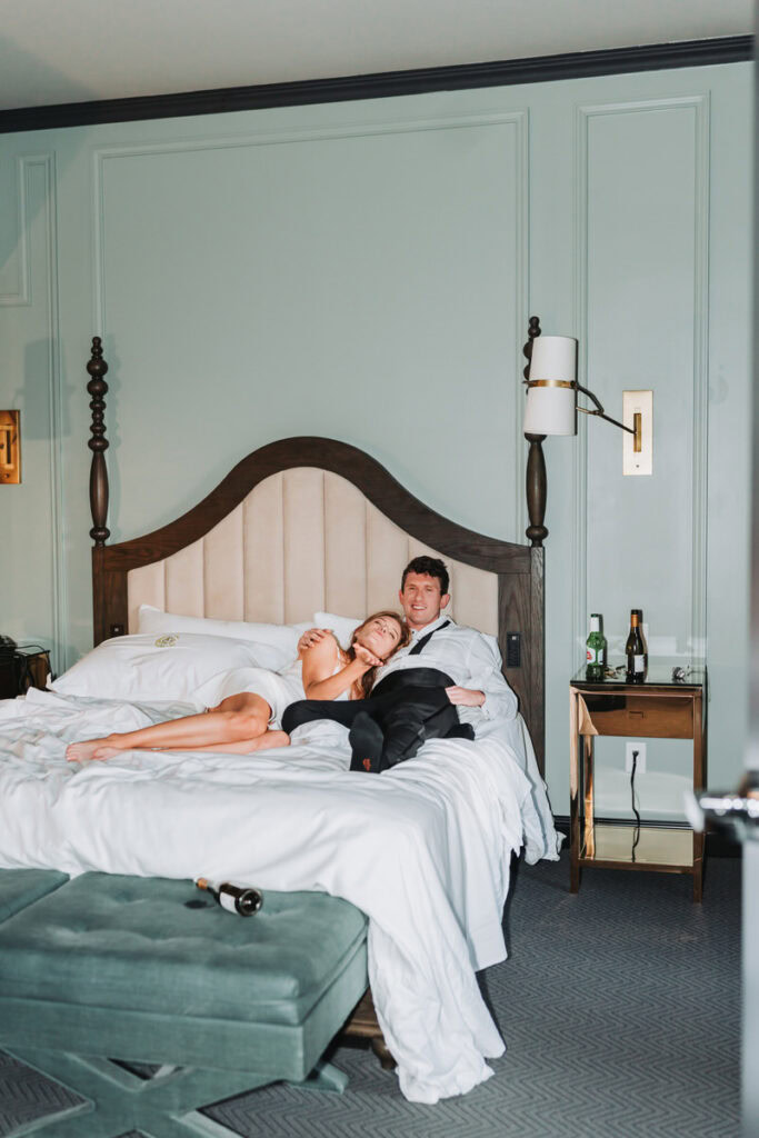 girl and guy lay on the bed and girl blows kisses to the camera.