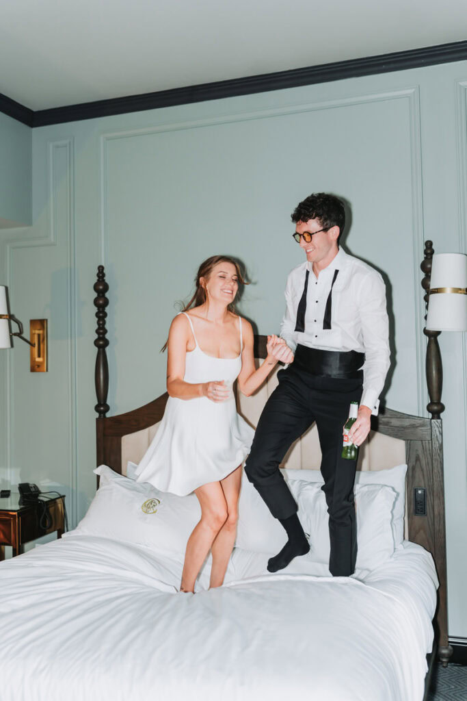 woman and man jump on the bed at candler hotel