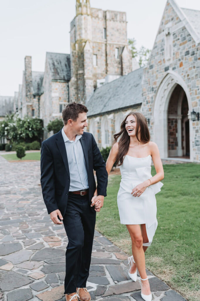 girl and guy walk towards on Berry College holding hands and laughing