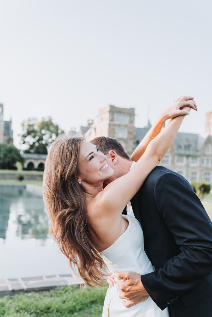 guy kisses girls neck as she has her hands in the air and smiles on Berry College campus