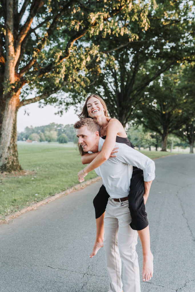 guy gives girl a piggy back ride. 