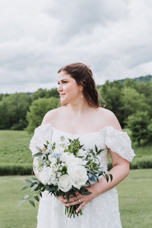 bride looks off into distance as she holds her bouquet