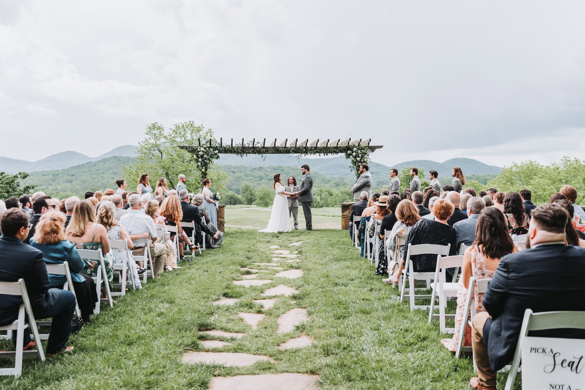 wide shot of bride and groom holding hands during their wedding ceremony