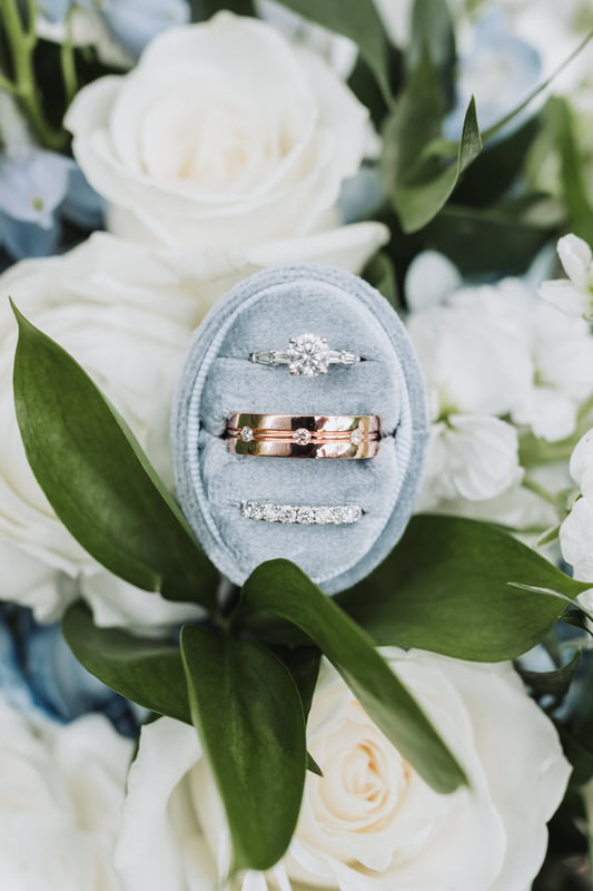 Wedding rings and blue ring box on flower bouquet