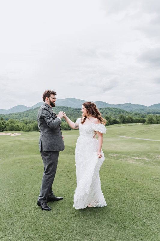 groom twirls bride in Brasstown Valley field