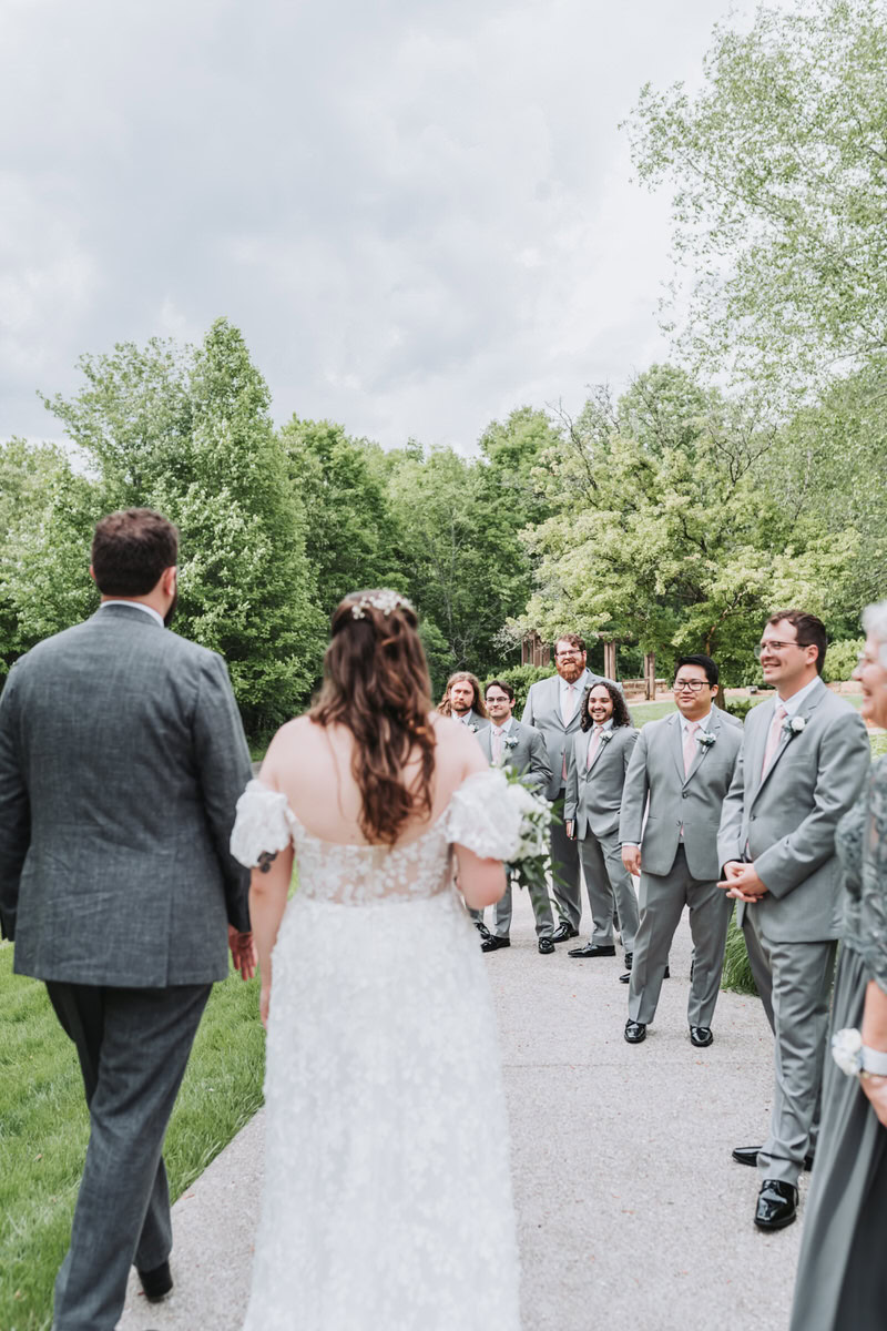 bride and groom walk over to groomsmen