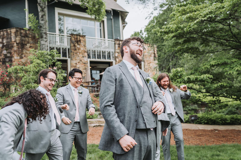 groom laughs as groomsmen are near him