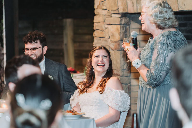 Bride laughs as mother gives a toast