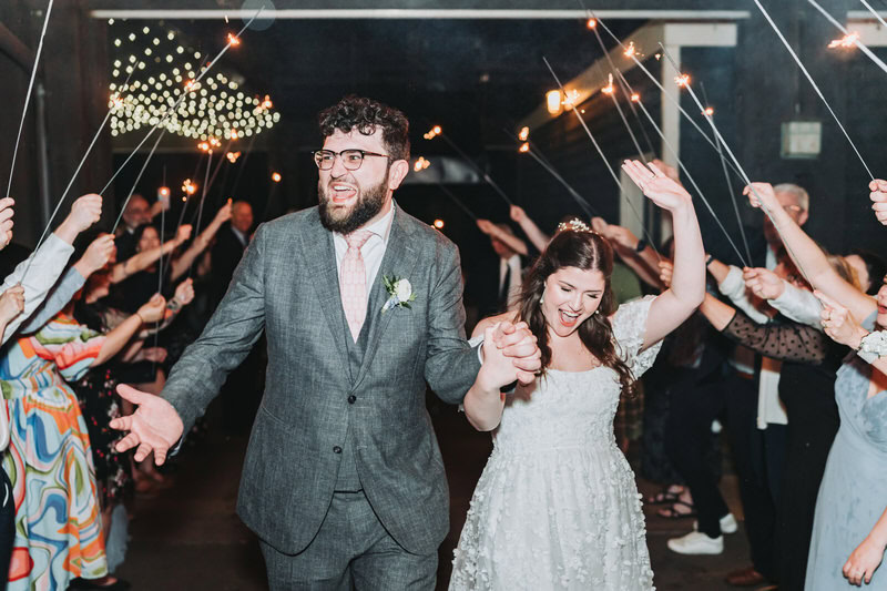 Bride and groom run through sparklers for their wedding exit