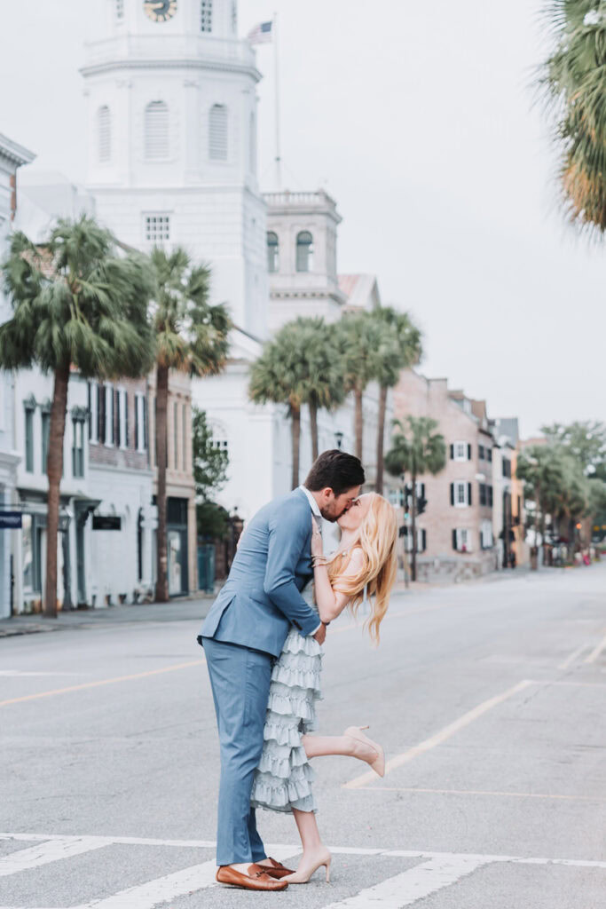 guy dips girl and kisses her in romantic downtown Charleston streets.