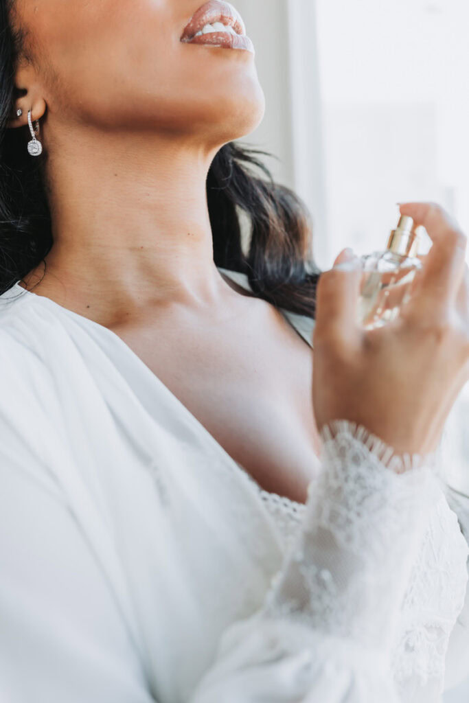 bride sprays perfume while getting ready at the Thompson Atlanta Hotel