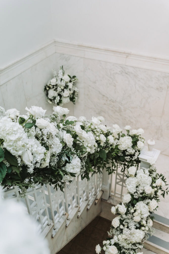 florals lining the stairs with marble courthouse backdrop