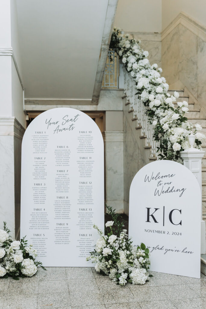 Wedding seating chart and custom welcome sign with marble courthouse backdrop