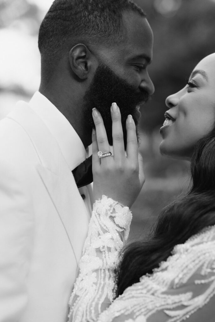 bride touches groom's face and smiles