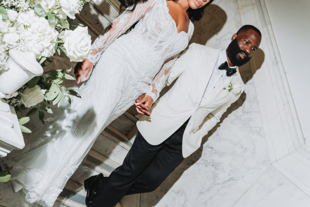 Bride and groom walk down the grand staircase at Historic Dekalb Courthouse