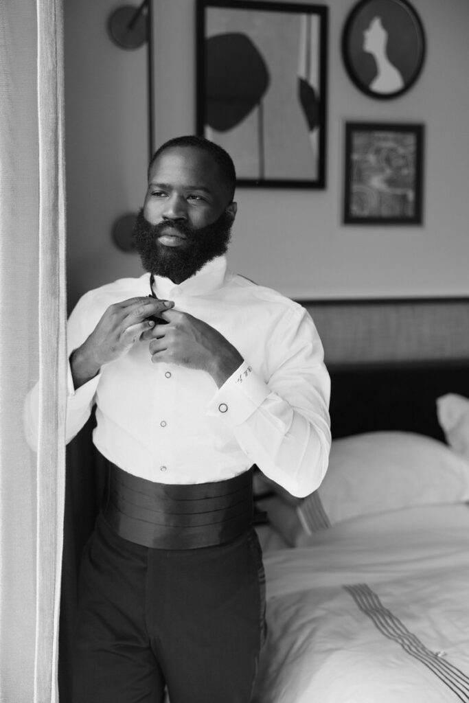 groom gets ready while looking out the window